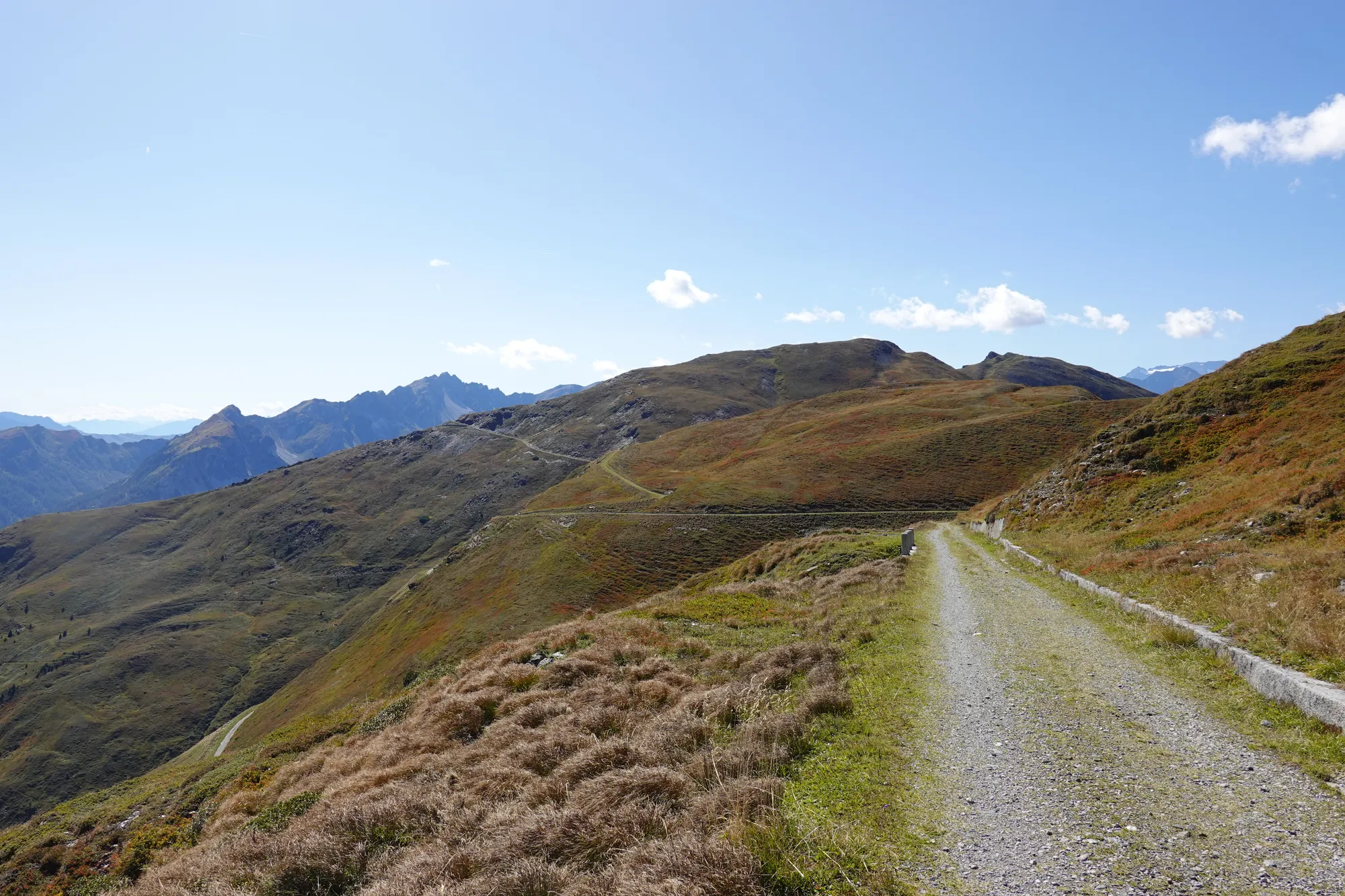 Gravelstraße am Brenner Grenzkamm, die sich über herbstlich braune Bergrücken zieht