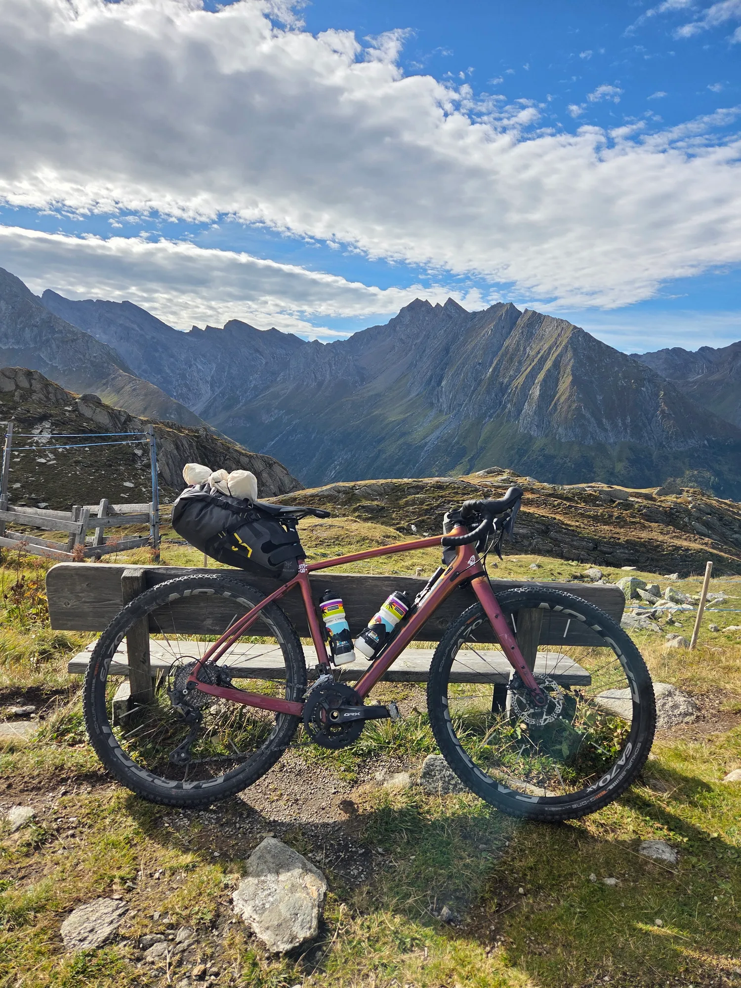Gravelbike an einer Holzbank mit Blick auf die Zillertaler Berge