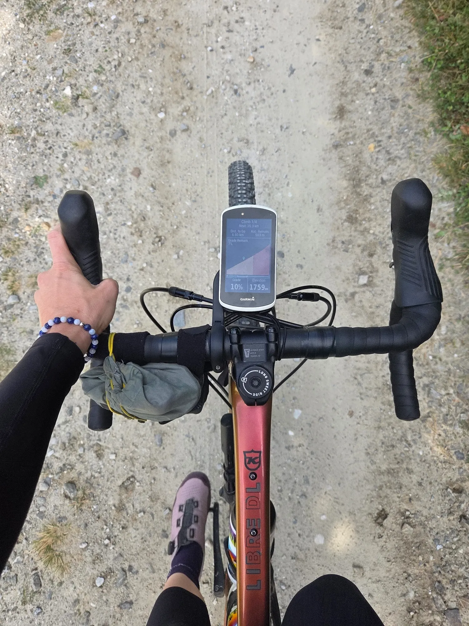 Blick vom Sattel auf Lenker, Radcomputer und Gravelweg