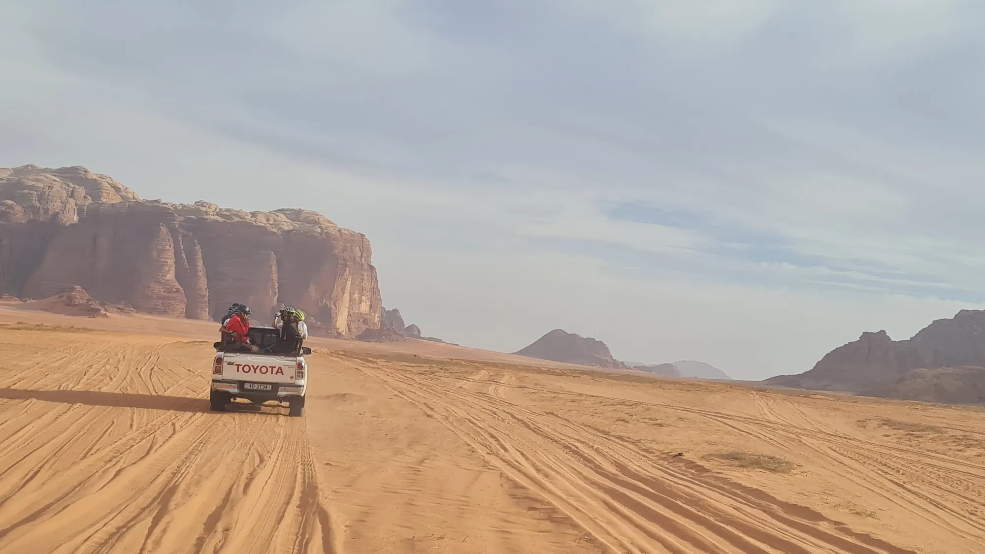 Jeep auf Sandpisten vor den Felsen des Wadi Rum