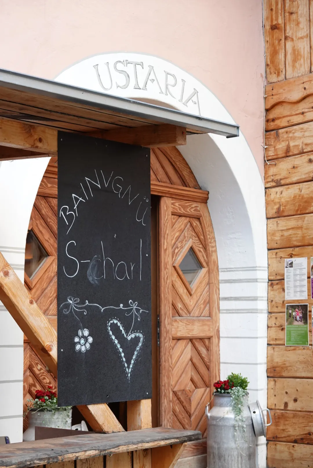 Kreidetafel mit „Bainvgnü S-charl“ am Eingang der Ustaria