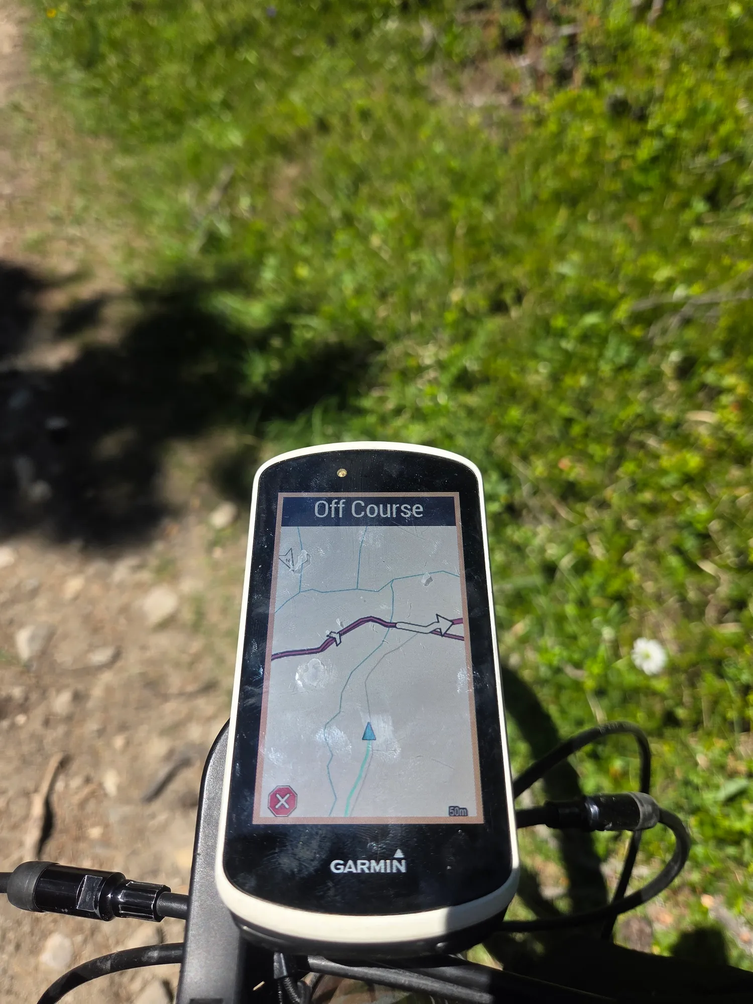 Radcomputer meldet „Off Course“ auf einem Wiesenpfad