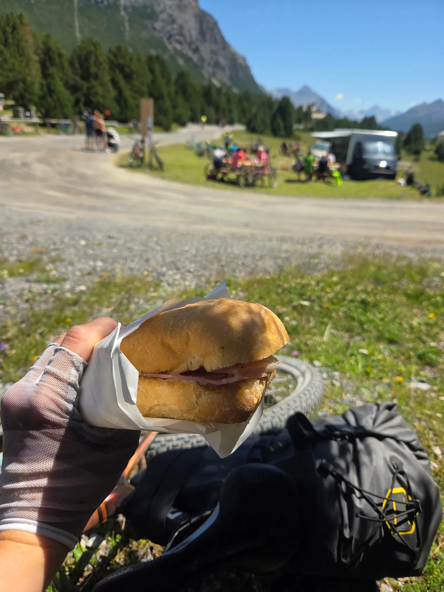 Sandwich in der Hand, im Hintergrund Picknickplätze am Seeufer