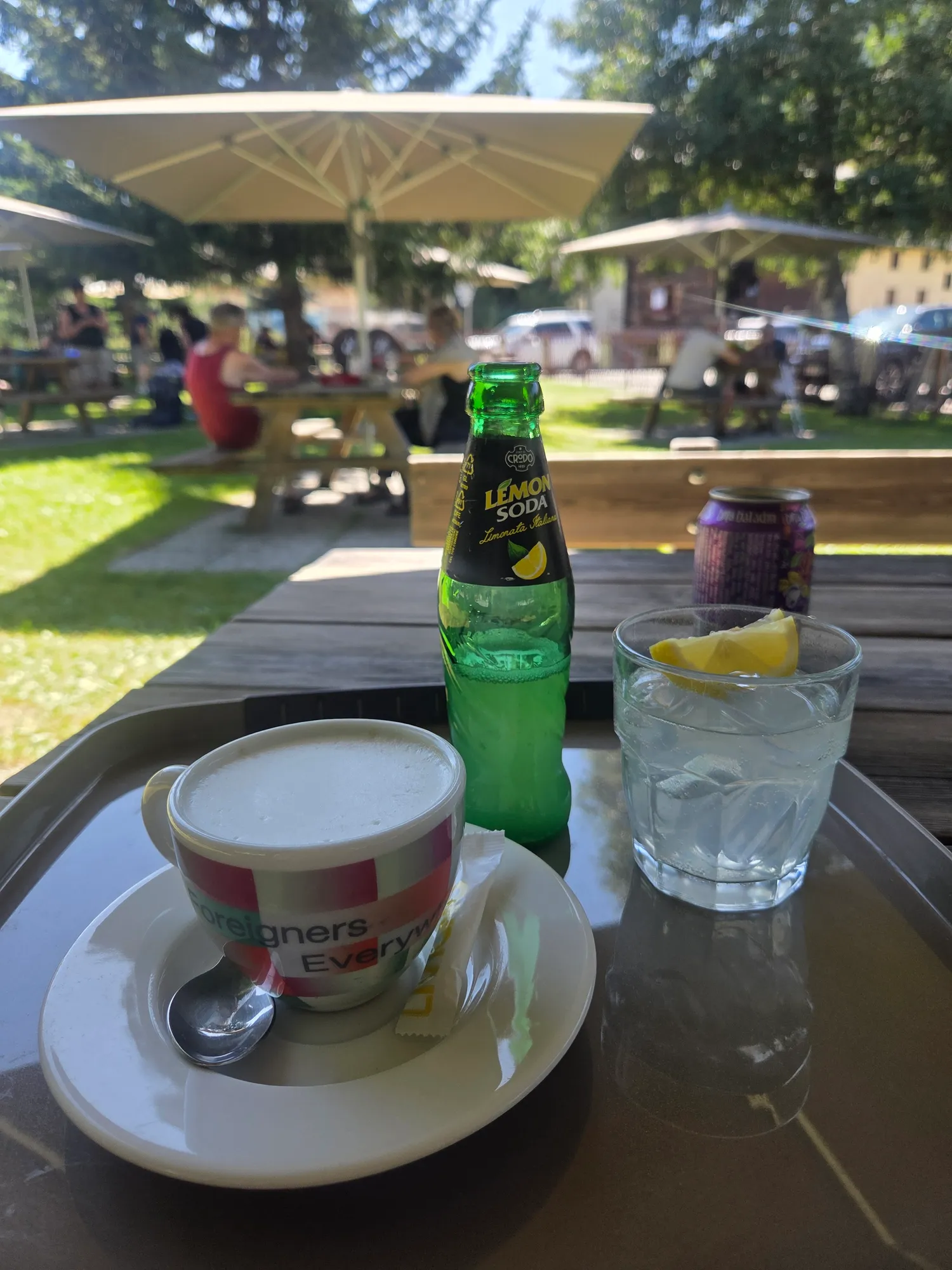 Espresso, Lemonsoda und ein Glas Wasser auf einem Terrassentisch in Livigno