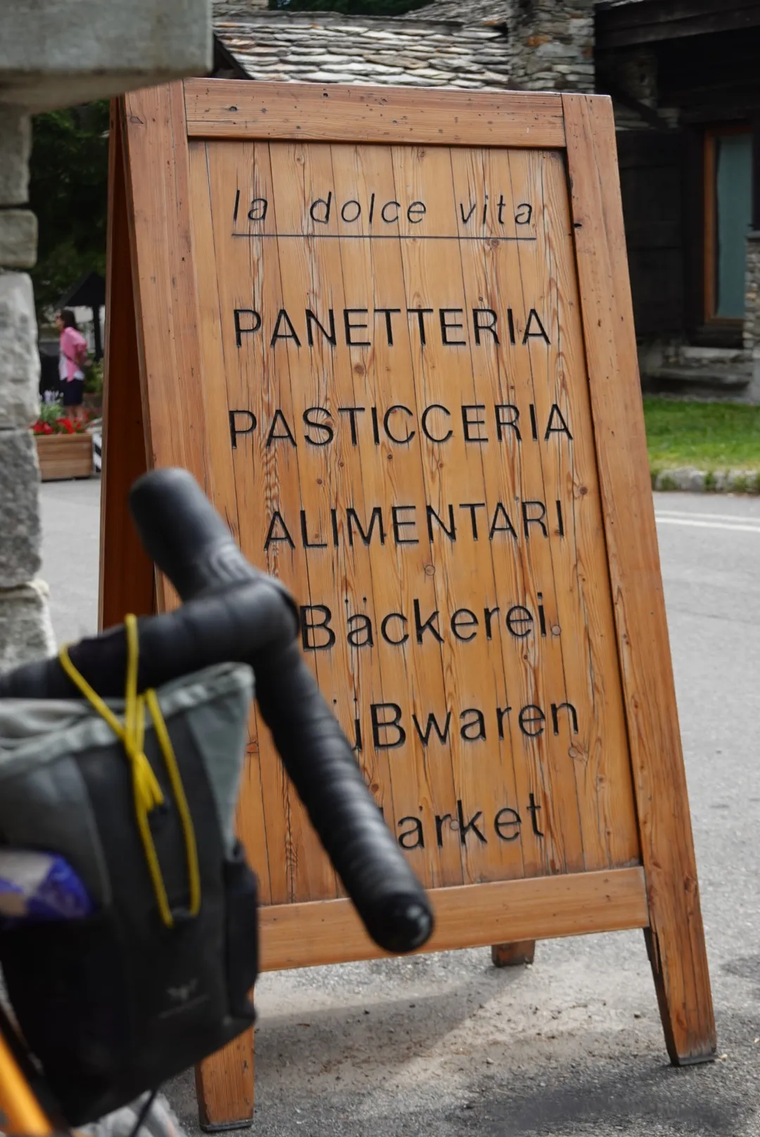 Aufsteller „la dolce vita – Panetteria, Pasticceria, Alimentari“ neben dem Lenker