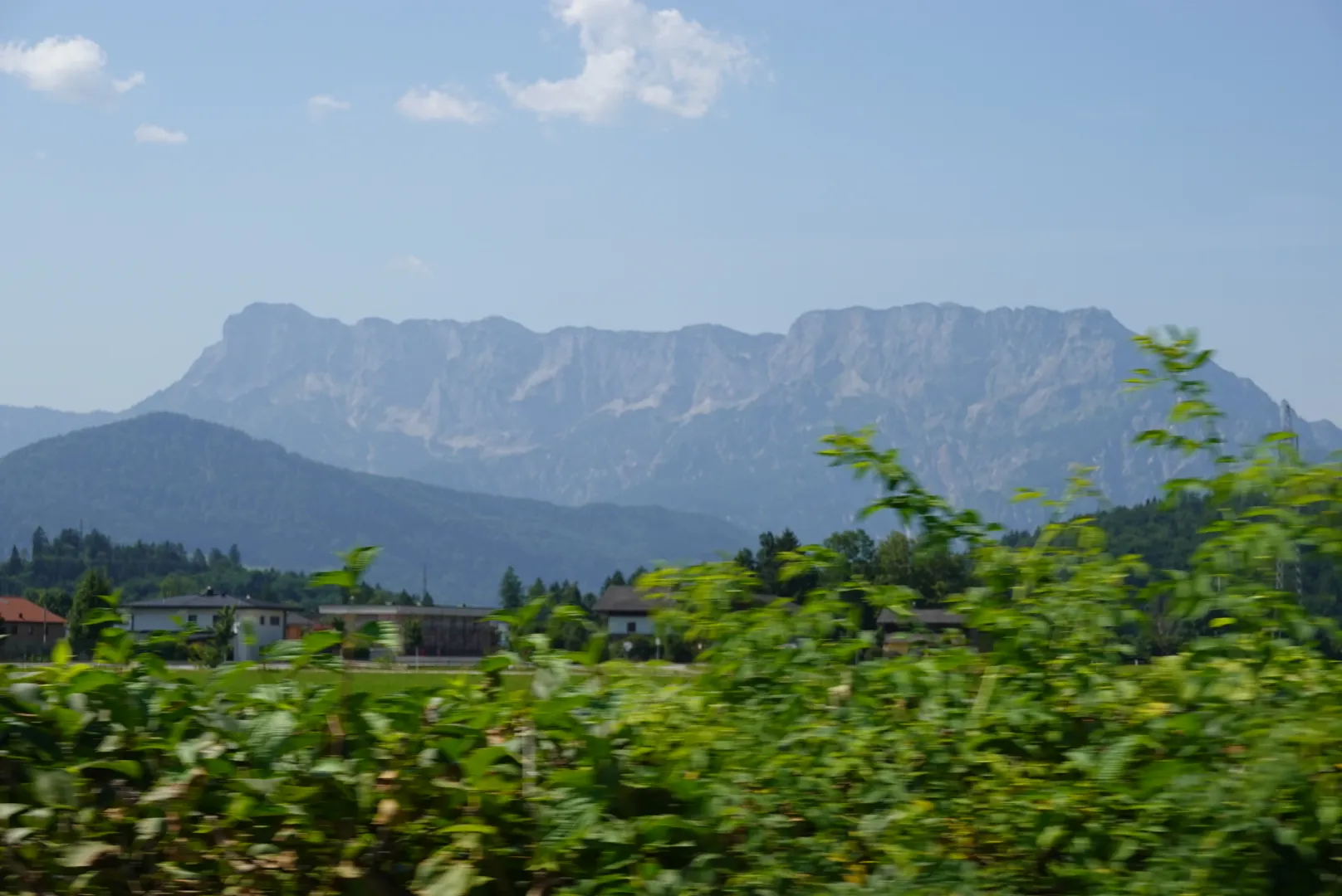 Breites Kalkmassiv über grünen Hecken