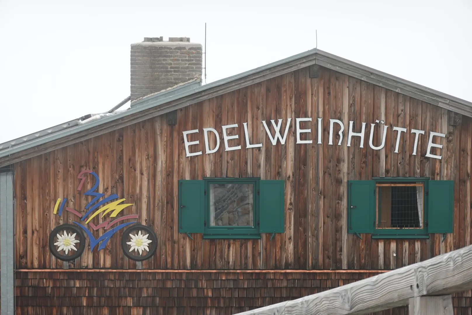 Holzfassade der Edelweißhütte mit grünen Fensterläden