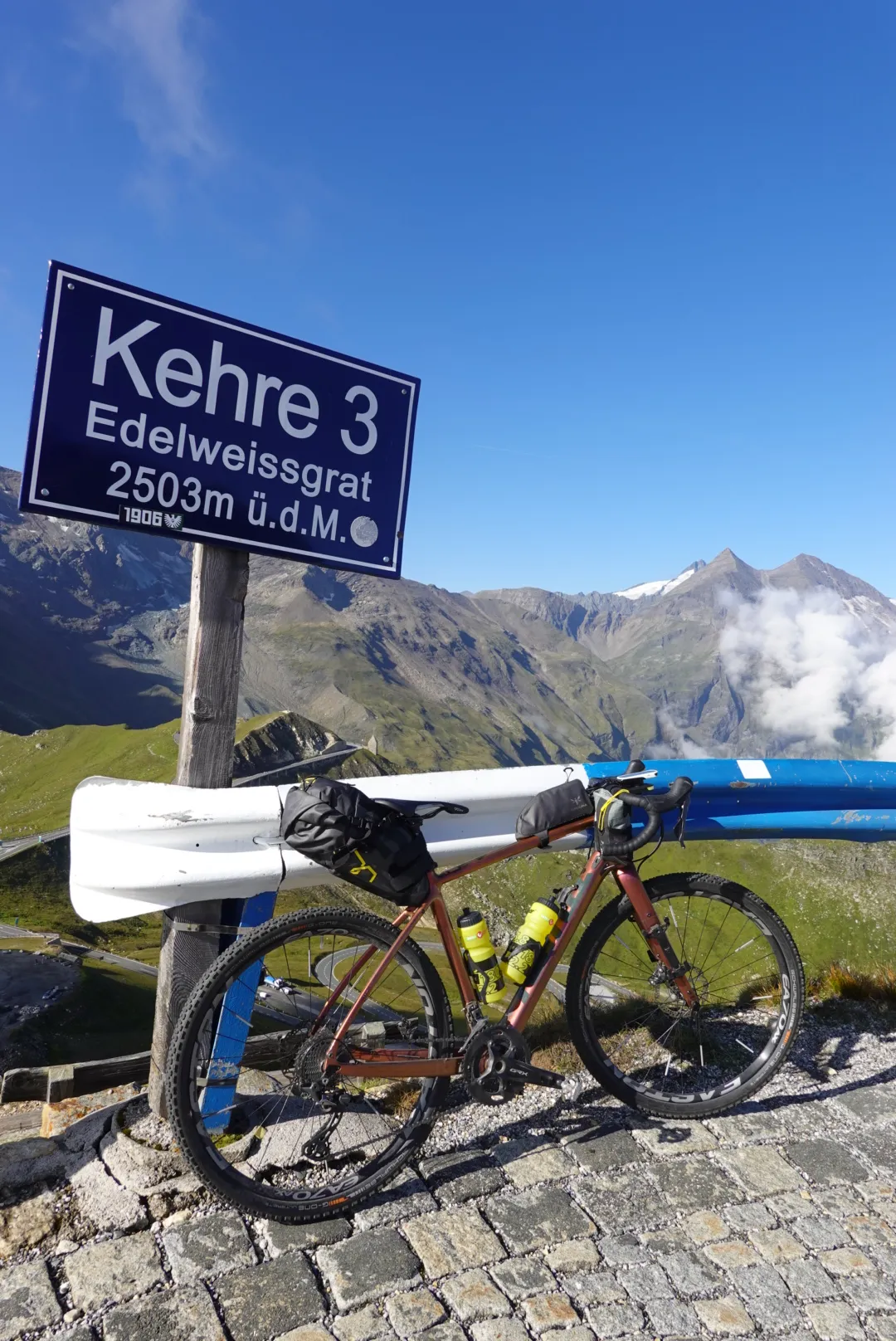 Gravelbike am Schild „Kehre 3 Edelweissgrat, 2503 m“