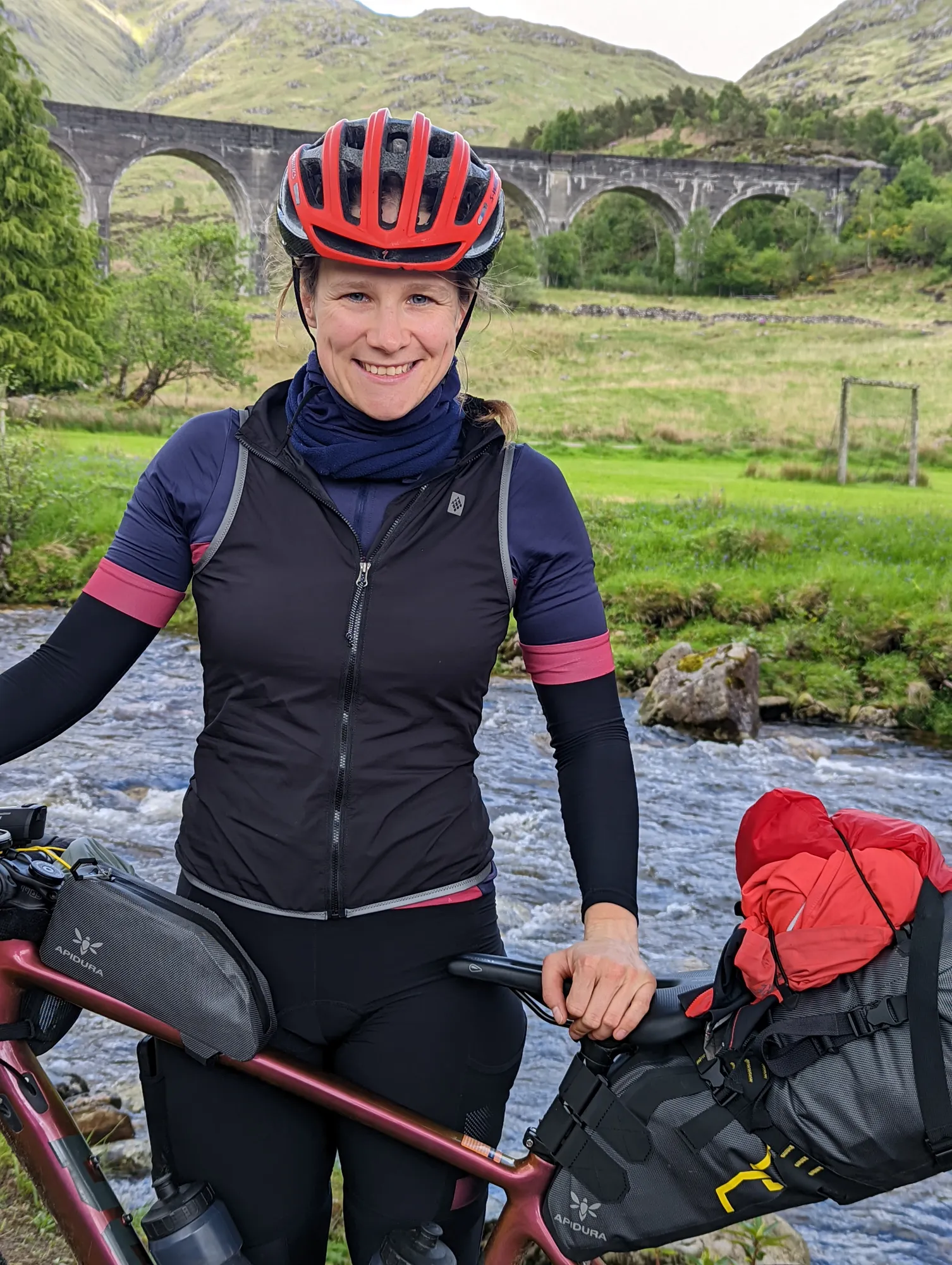 Carla lachend mit Helm vor dem Glenfinnan-Viadukt
