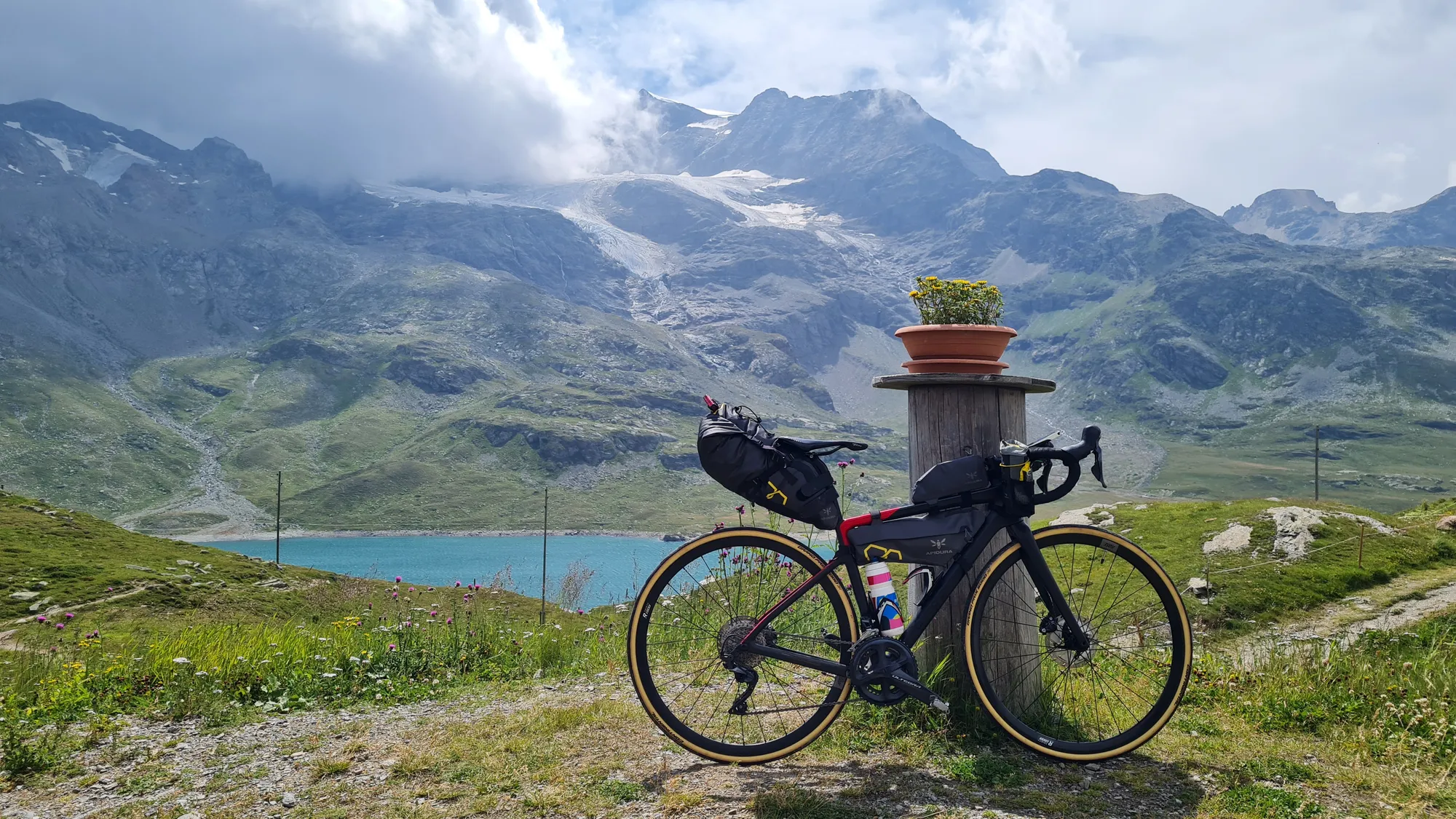 Rad vor dem türkisen Lago Bianco und den Gletschern am Berninapass