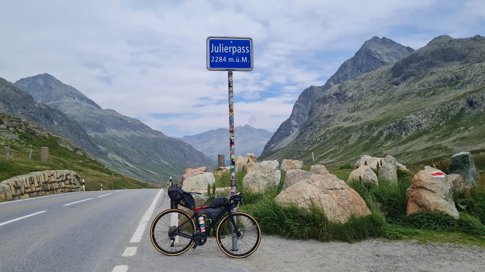 Rad am Schild Julierpass, 2284 m, zwischen Felsblöcken
