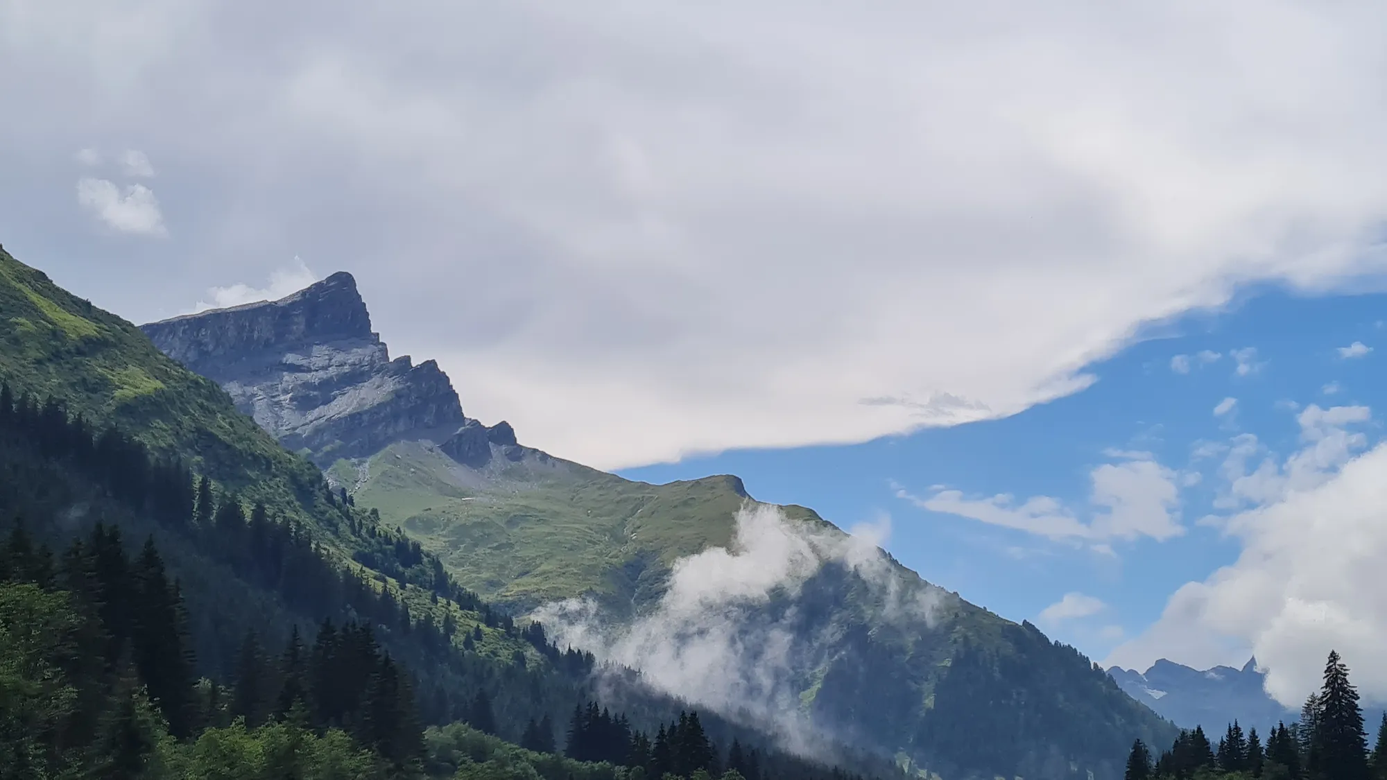 Wolkenfetzen an den Felsgipfeln über dem Rheinwald