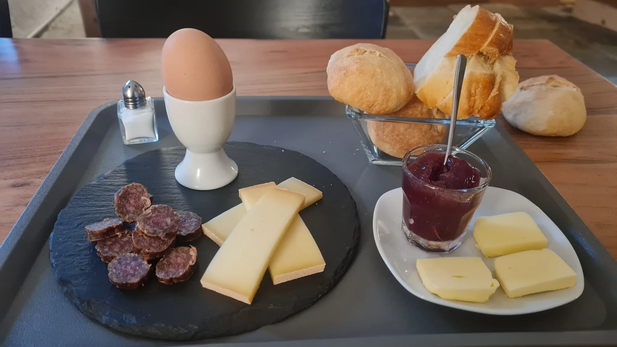 Frühstück mit Ei, Käse, Trockenwurst und Marmelade