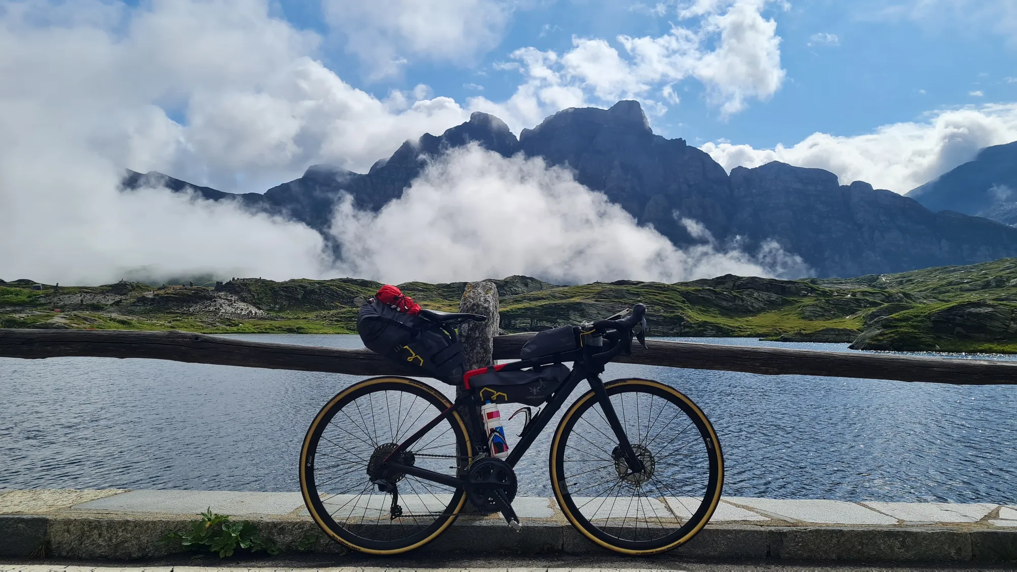 Rad am Bergsee auf dem San Bernardino, Wolken zwischen den Gipfeln
