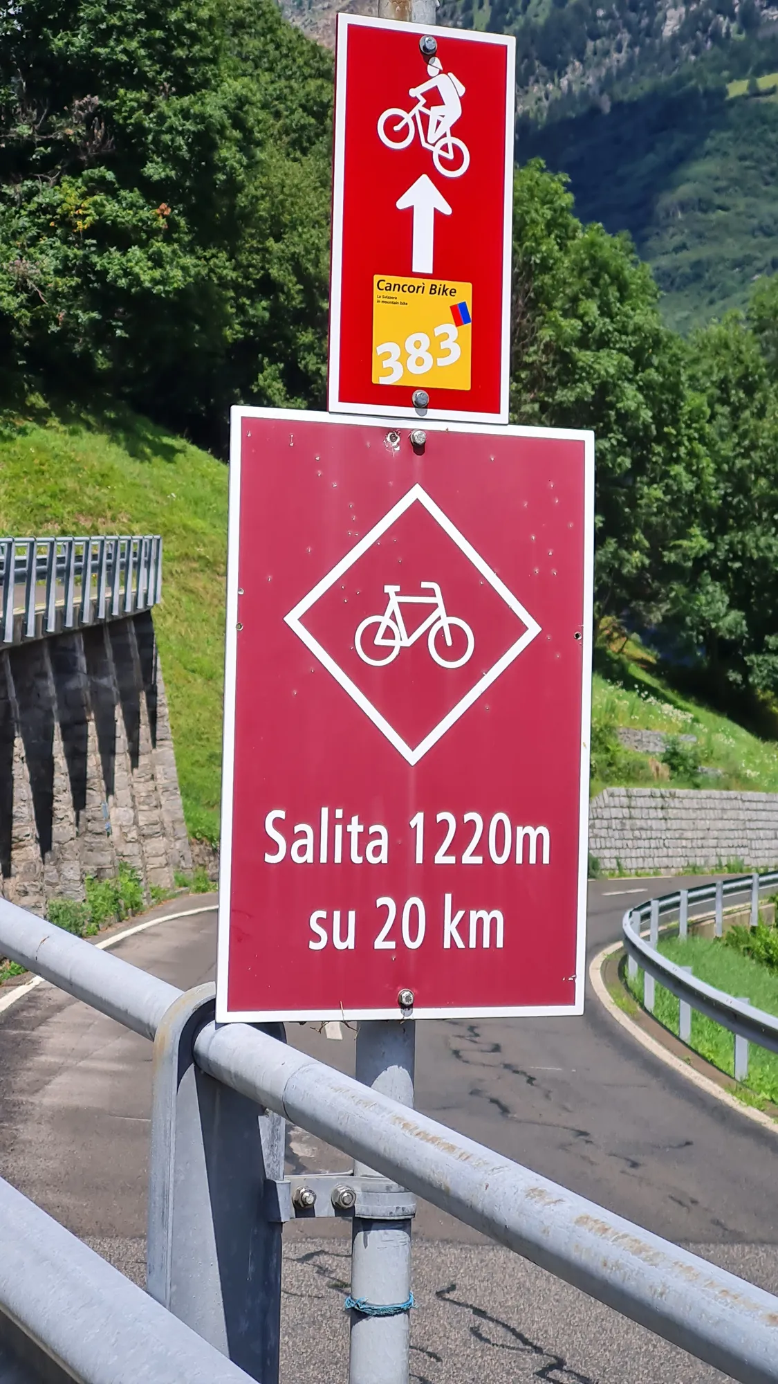 Radwegschild zum Lukmanier: Salita 1220 m su 20 km