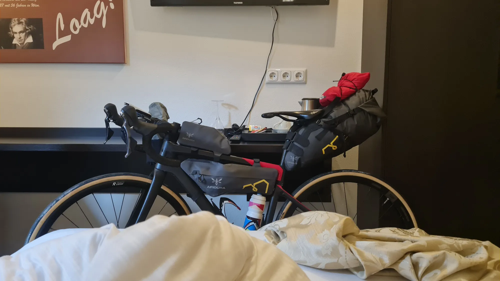 Bepacktes Rad im Zimmer, davor die zerwühlte Bettdecke