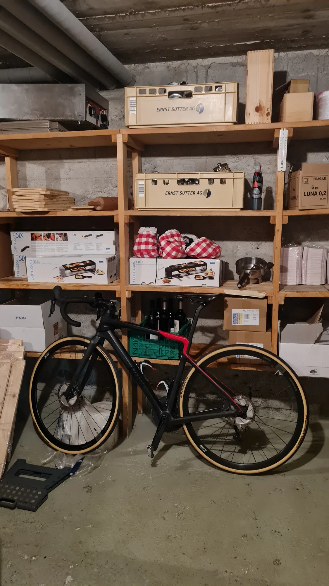 Rad im Vorratsraum des Hospiz zwischen Regalen und Raclette-Gerät